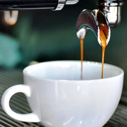 Espresso fließt in Cappuccino Tasse Espresso fließt in die Tasse